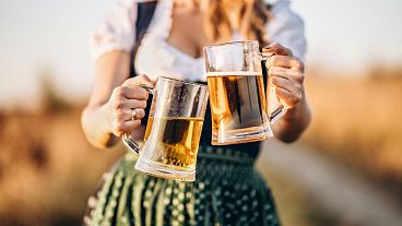 Woman in Dirndl Holding Glasses of Beer Woman in Dirndl Holding Glasses of Beer