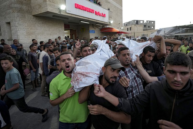 فلسطينيون يحملون جثث أقاربهم الذين قتلوا في القصف الإسرائيلي على قطاع غزة في مستشفى في دير البلح