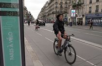 Una donna in bicicletta sulla pista ciclabile di Parigi