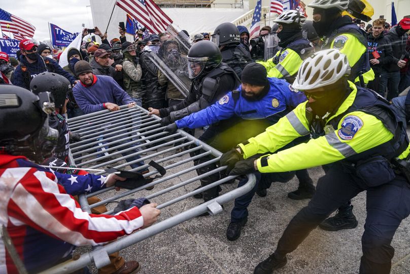 Manifestanti provano a sfondare una barriera della polizia statunitense al Campidoglio, Washington, DC, il 6 gennaio 2021.