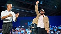 Rapper Eminem greets the crowd on stage with former President Barack Obama on Tuesday, 22 October at a campaign rally in Detroit. 