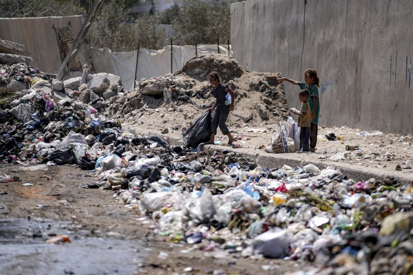 Vertriebene Kinder sortieren Müll in einer Straße in Deir al-Balah, im zentralen Gazastreifen, Dienstag, 27. August 2024.