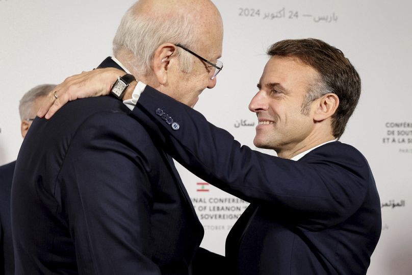 France's President Emmanuel Macron hugs Lebanon's caretaker Prime Minister Najib Mikati.