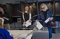 Local residents vote at a polling station during the advance voting in the second round of a parliamentary election in Vilnius, Lithuania, Tuesday, Oct. 22, 2024.