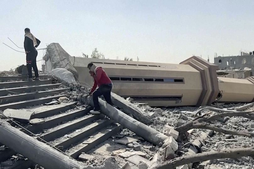 مواطنون يراقبون مسجدًا دمره القصف الجوي الإسرائيلي في مدينة خان يونس جنوب قطاع غزة 25 تشرين الأول أكتوبر 2024