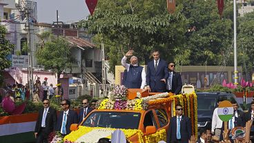 Le Premier ministre indien Narendra Modi, au centre à gauche, et son homologue espagnol Pedro Sanchez, au centre à droite, saluent les gens depuis un véhicule à Vadodara, en Inde. 28 octobre 2024.