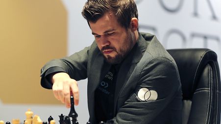 Norway's World Chess Champion Magnus Carlsen, makes a move against Ian Nepomniachtchi of Russia, during their Game One of the FIDE World Championship at the Dubai Expo, 2021
