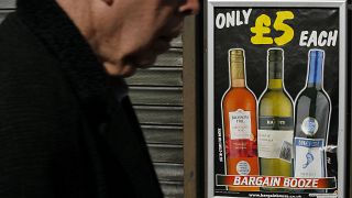 A pedestrian passes by a UK shop selling cheap alcohol products in 2012, before Scotland's minimum pricing policy went into effect in 2018.