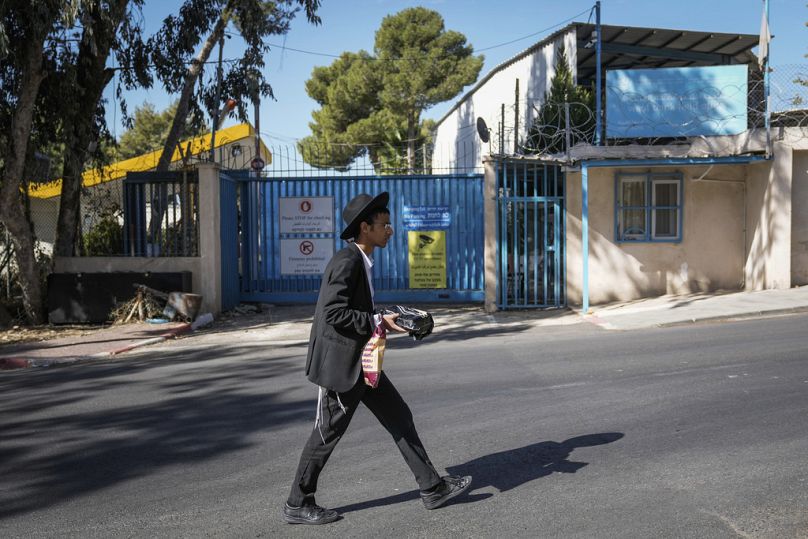 مستوطن إسرائيلي يمر من أمام مقر "الأونروا في القدس.