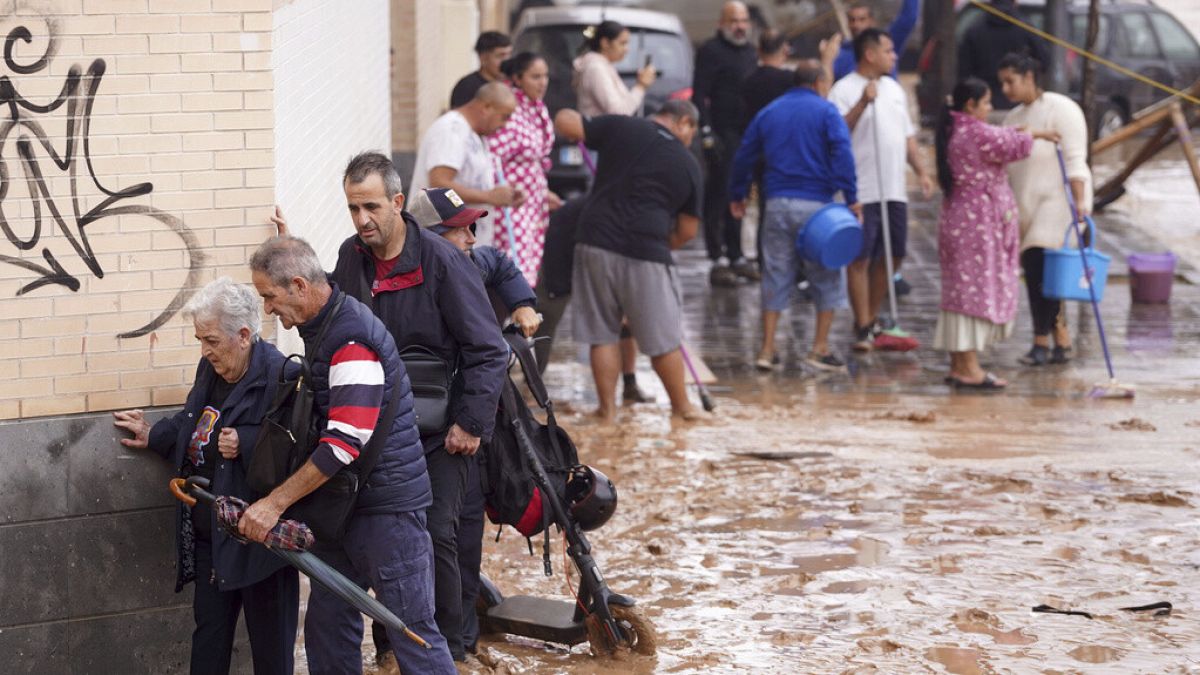 People walk through flooded streets in Valencia