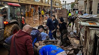 Persone puliscono le loro case alluvionate a Utiel, Valencia, Spagna, 30 ottobre 2024