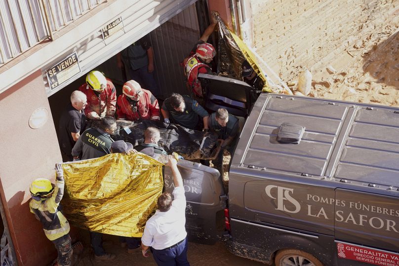 Members of the Spanish Guardia Civil carry the body of a person who died during floods in Valencia