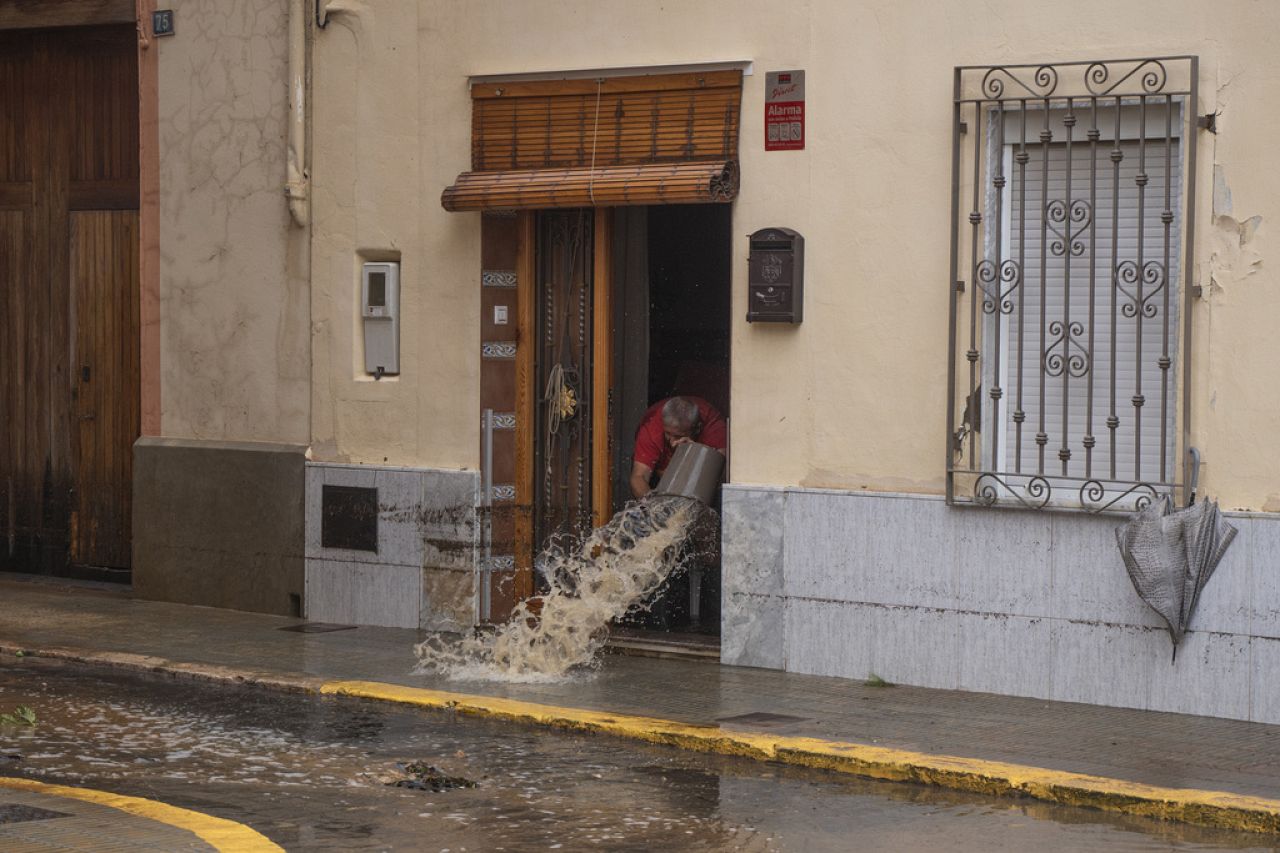 Un homme jette l'eau hors de sa maison après les inondations à Valence, en Espagne.