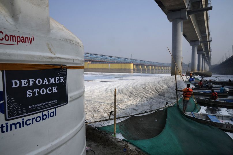 Workers for the Delhi Jal or water board spray chemical to clean the toxic foams in the river Yamuna in New Delhi, India, Tuesday, Oct. 29, 2024.