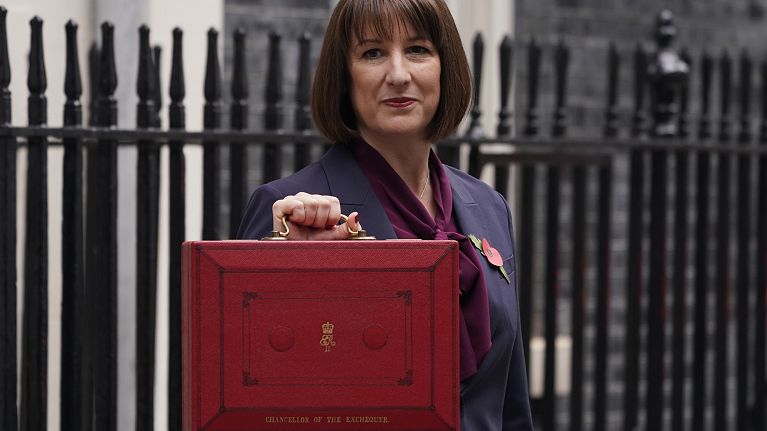 Britain's Chancellor of the Exchequer, Rachel Reeves, holds up the traditional red ministerial box containing her budget speech, as she poses for the media outside Downing St