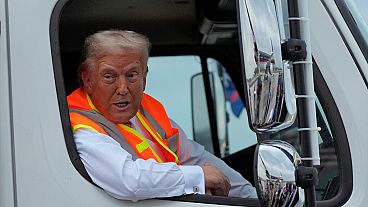 Republican presidential nominee former President Donald Trump talks to reporters as he sits in a garbage truck Wednesday, Oct. 30, 2024, in Green Bay, Wis. 