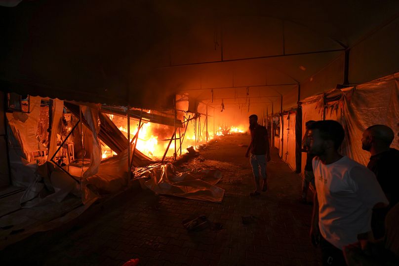 فلسطينيون يتفاعلون مع حريق بعد غارة إسرائيلية أصابت خيمة في باحة مستشفى شهداء الأقصى في دير البلح بقطاع غزة، الاثنين 14 أكتوبر/تشرين الأول 2024