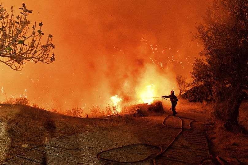 A firefighter tries to extinguish the flames near the Greek village of Kallithea in September