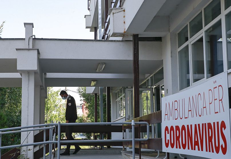 A security guard walks outside the ambulance parking area dedicated to COVID-19 patients at the Clinic for Infectious Diseases in Pristina, Kosovo.