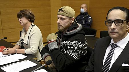Russian national Yan Petrovsky, who also goes under the name Voislav Torden (center), sits in Helsinki District Court in December 2023