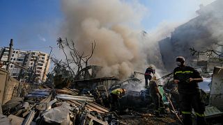 Civil defense workers extinguish a fire as smoke rises from the site of an Israeli airstrike in Dahiyeh, Beirut, Lebanon, Friday, Nov. 1, 2024. 