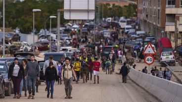 People walk toward Valencia after helping with cleaning efforts in an area affected by floods in Sedavi, 1 November, 2024 People walk toward Valencia after helping with cleaning efforts in an area affected by floods in Sedavi, 1 November, 2024