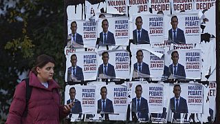 A woman walks past posters displaying Alexandr Stoianoglo, presidential candidate of the Socialists' Party of Moldova (PSRM) in Chisinau, Moldova, Friday Nov. 1, 2024. 