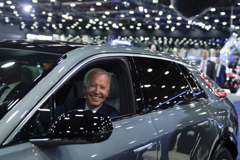 President Joe Biden drives a Cadillac Lyriq through the showroom during a tour at the Detroit Auto Show.