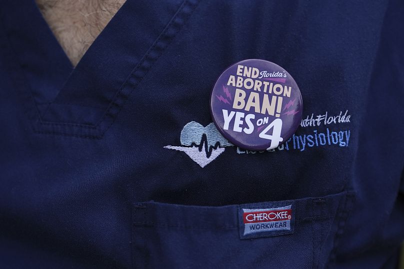 A doctor wears a button on his scrubs in support of Florida's Amendment 4, which would enshrine abortion rights in the state.