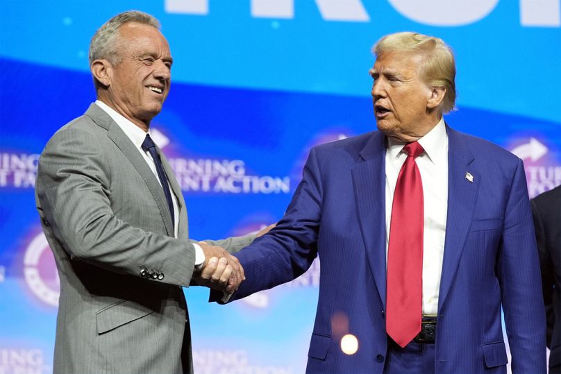 Republican presidential nominee former President Donald Trump shakes hands with Robert F. Kennedy Jr., at a Turning Point Action campaign rally, Wednesday, Oct. 23, 2024.