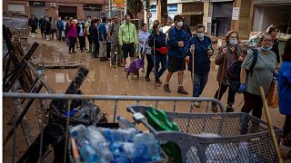 Residents wait to receive drinking water in an area, affected by floods, in Paiporta, Valencia.