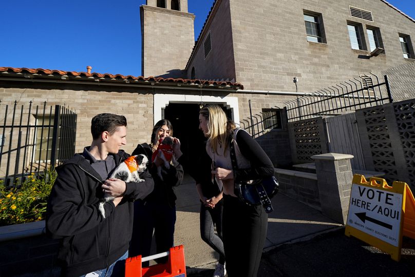 Eleitores com os seus cães à porta de uma assembleia de voto em Phoenix, Arizona