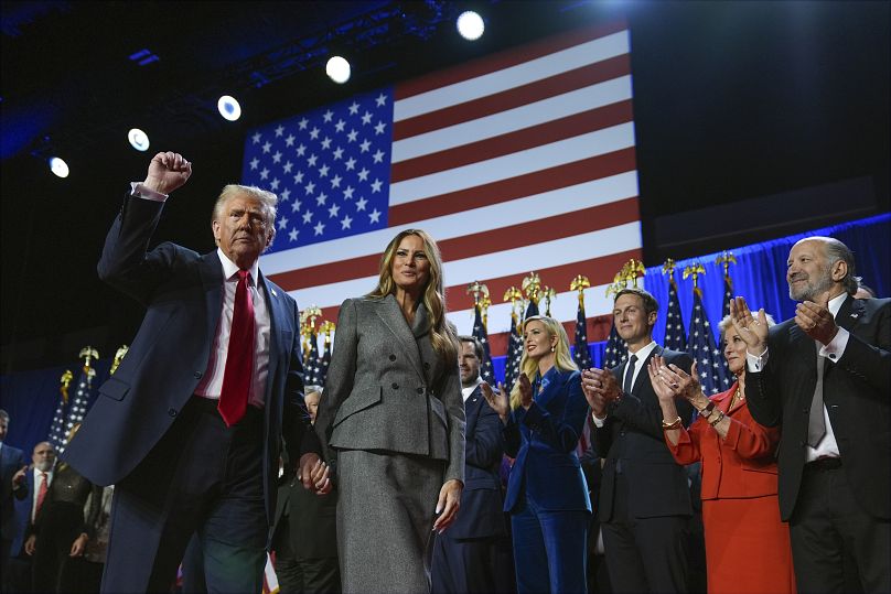 Donald Trump gestures as he walks with former first lady Melania Trump at an election night watch party 