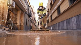 Un vigile del fuoco spazza via il fango dopo un'alluvione a Paiporta, 7 novembre 2024