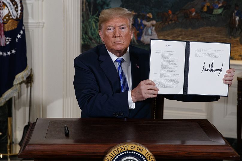 الرئيس الأميركي دونالد ترامب يعرض مذكرة رئاسية موقعة بعد إلقاء بيان حول الاتفاق النووي الإيراني من غرفة الاستقبال الدبلوماسي في البيت الأبيض، في 8 مايو/أيار 2018