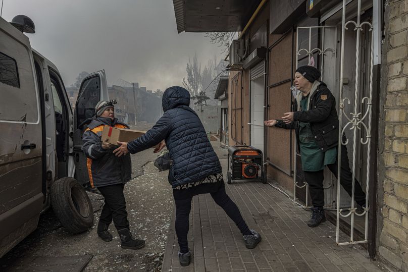 Local women unload food products from a minivan into the last shop operating in Kurakhove, Donetsk region, Ukraine, on Nov. 7, 2024. (AP Photo/Anton Shtuka)