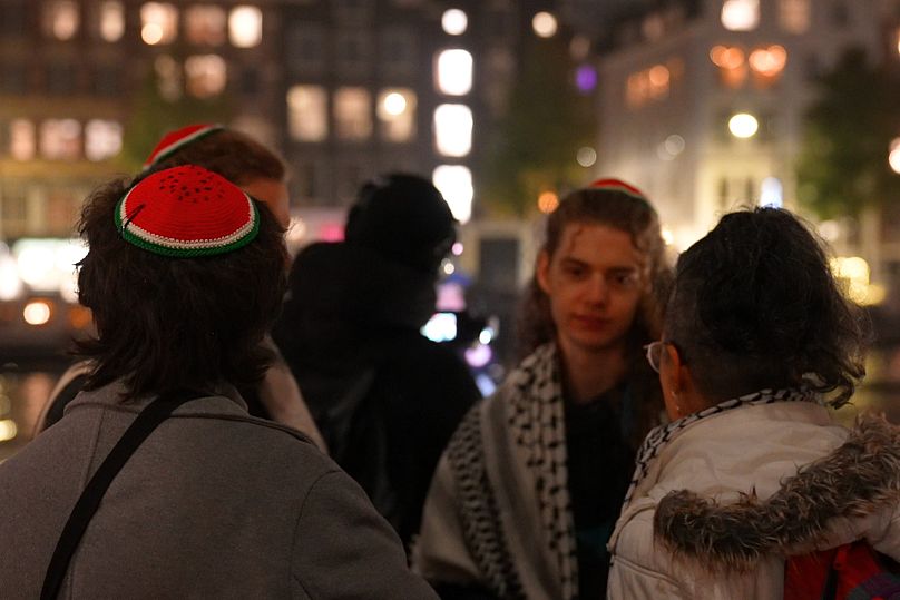 Individuals wearing watermelon Kippah and Keffiyeh at a gathering at the Monument to Jewish Resistance.