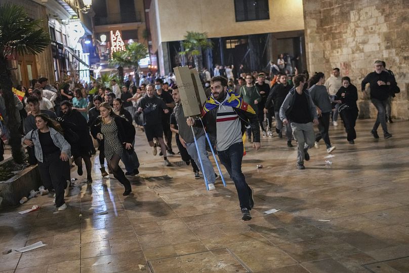 Demonstrators run away from riot police during minor clashes after a peaceful protest denouncing the handling of the recent flooding, 9 November, 2024