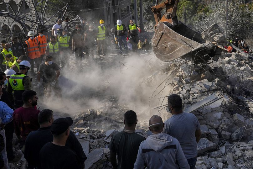 Des secouristes et des habitants cherchent des victimes sous les décombres d'une maison détruite par une frappe aérienne israélienne, dans le village d'Aalmat, au nord Liban