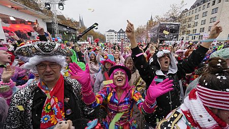 Kostümierte feiern auf dem zentralen Heumarkt, während Zehntausende von Karnevalsnarren durch die Straßen von Köln ziehen, Deutschland, Montag, 11. November 2024