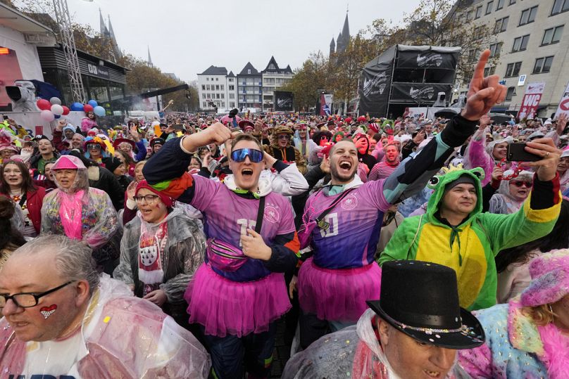 Des fêtards costumés font la fête au Heumarkt central pour le carnaval de Cologne, en Allemagne.