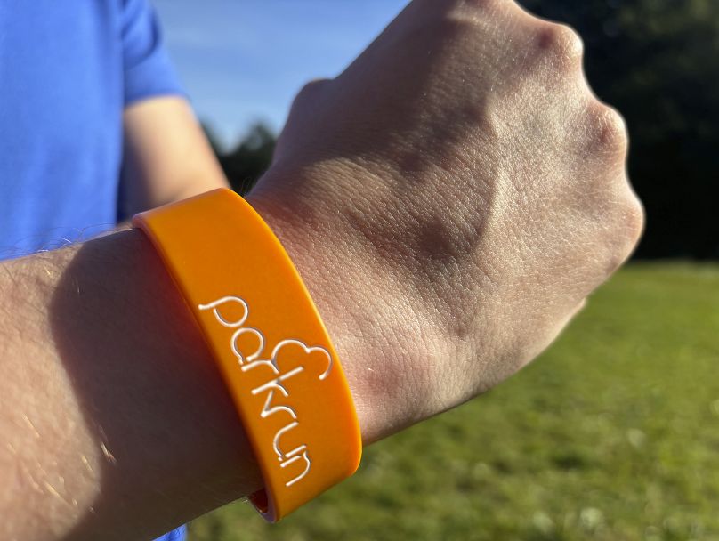 A runner shows off a parkrun wrist band after completing the 5 kilometer (3.1 mile) route in Hampstead Heath in north London on Saturday 14 September 2024.