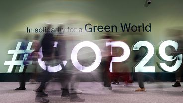 People walk through the COP29 UN Climate Summit. People walk through the COP29 UN Climate Summit.