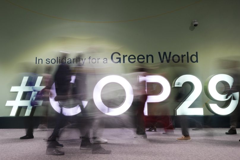 People walk through the COP29 UN Climate Summit in Baku, November 2024