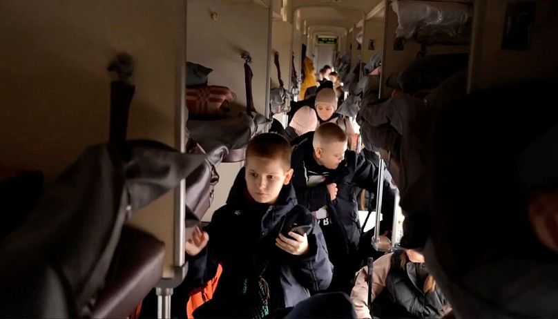 children deported from Ukraine board a train to relocate to Russia