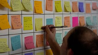 Man putting sticky note on the wall of subway tunnel as part of 'Subway Therapy.'