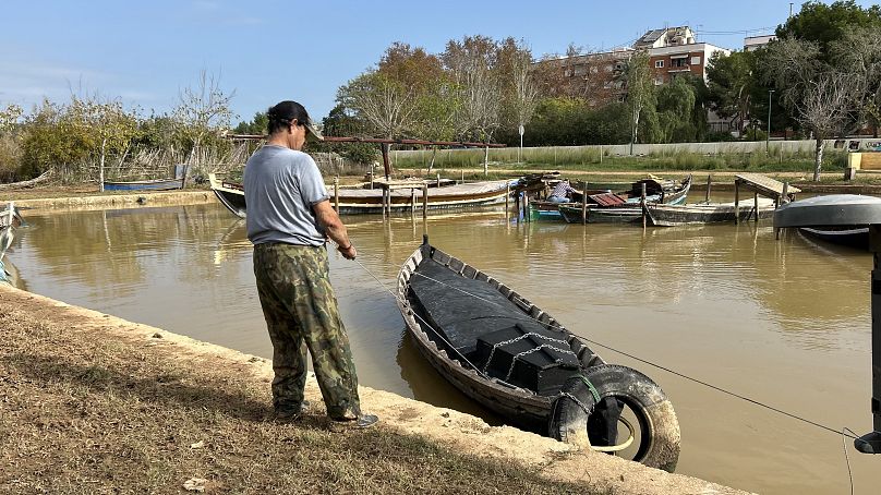 Local boat guide Pacino retrieves his boat from the flooded water