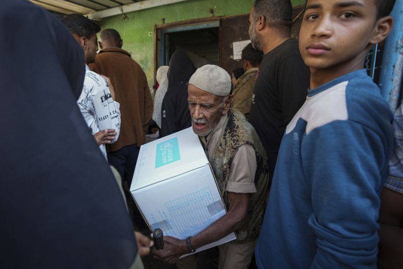 Des Palestiniens reçoivent de l'aide distribuée par l'UNRWA, dans le camp de réfugiés de Nusairat, à Gaza, le 5 novembre 2024.