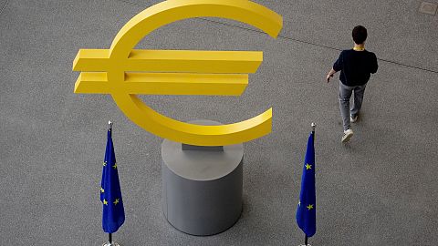 A man walks past a euro sign in the hallway of the European Central Bank in Frankfurt, Germany