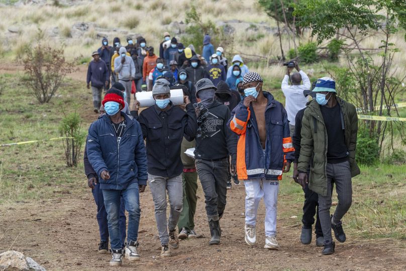 Volunteer rescue workers and community members leave a mine shaft where illegal miners are trapped in a disused mine in Stilfontein, South Africa, Thursday, Nov. 14, 2024. 